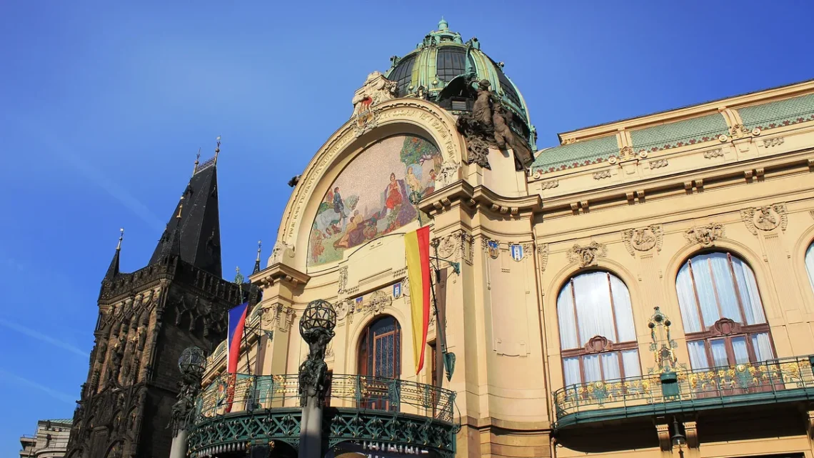 Secesní průčelí Obecního domu v Praze s mozaikou nad vchodem a gotickou Prašnou bránou vlevo