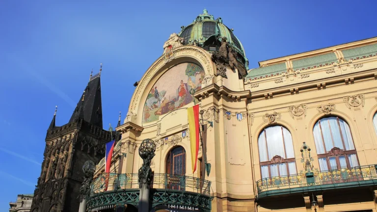 Secesní průčelí Obecního domu v Praze s mozaikou nad vchodem a gotickou Prašnou bránou vlevo