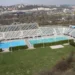 Venkovní bazény Plaveckého stadionu Podolí s tribunou, loukou a tobogánem, pohled shora