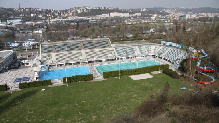 Venkovní bazény Plaveckého stadionu Podolí s tribunou, loukou a tobogánem, pohled shora
