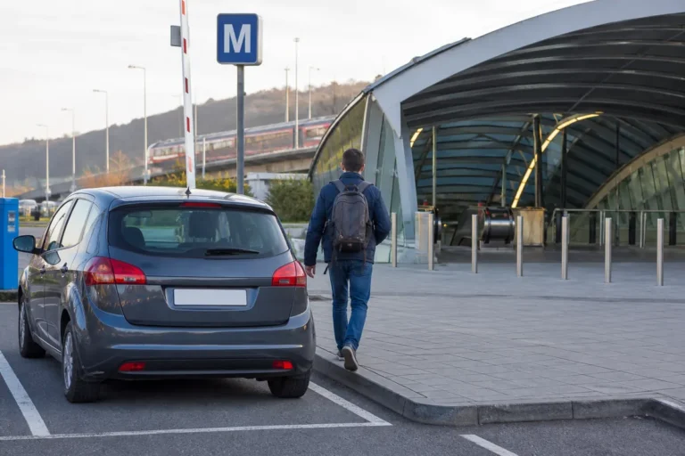 Řidič odchází od zaparkovaného auta ke stanici metra na pražském P+R