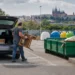 Pražan vykládá starou dřevěnou židli z auta ve sběrném dvoře