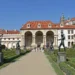 Sala terrena ve Valdštejnské zahradě s bronzovými sochami podél hlavní cesty a Pražským hradem v pozadí