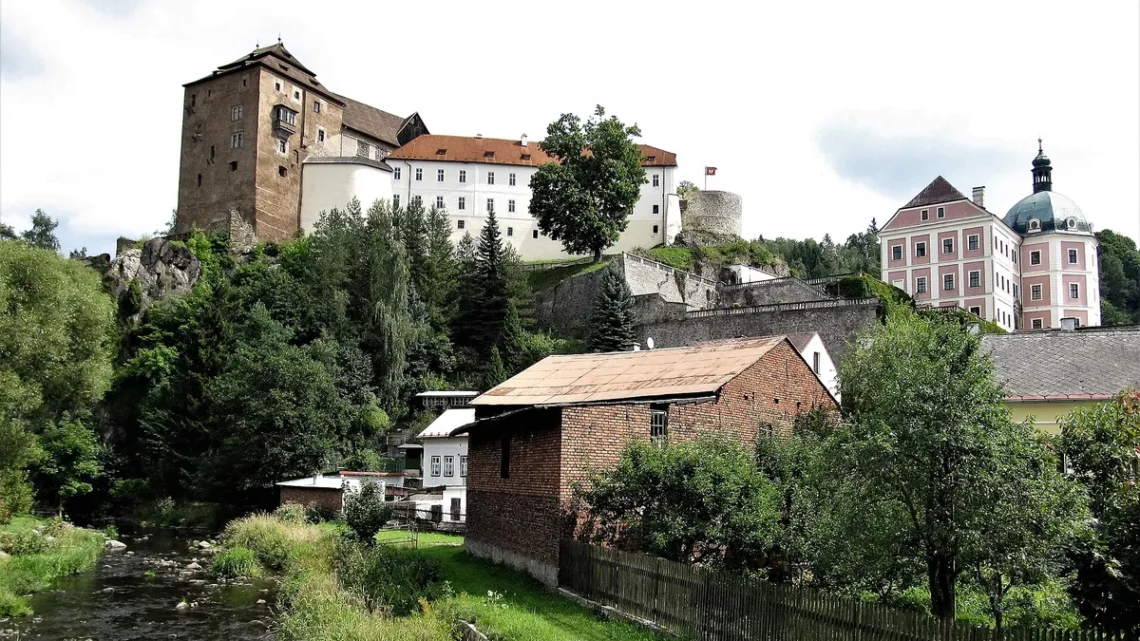 Hrad a zámek Bečov nad Teplou nad říčkou Teplá, vlevo donjon, vpravo barokní zámek s věží