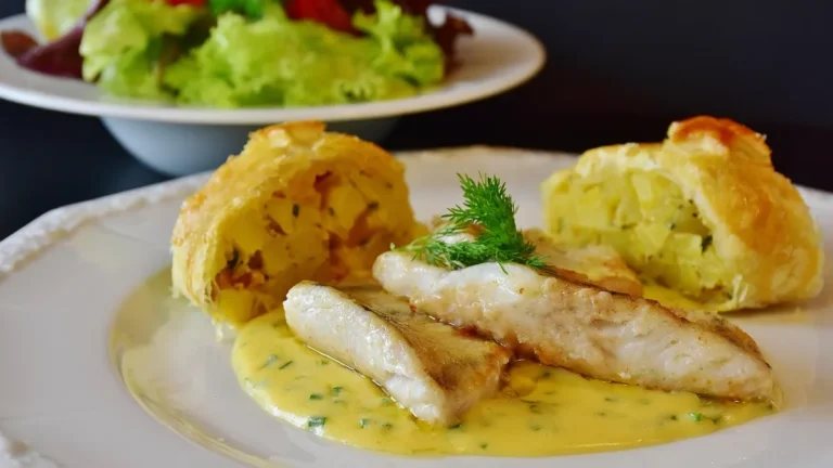 Filet candáta s omáčkou a přílohou na talíři