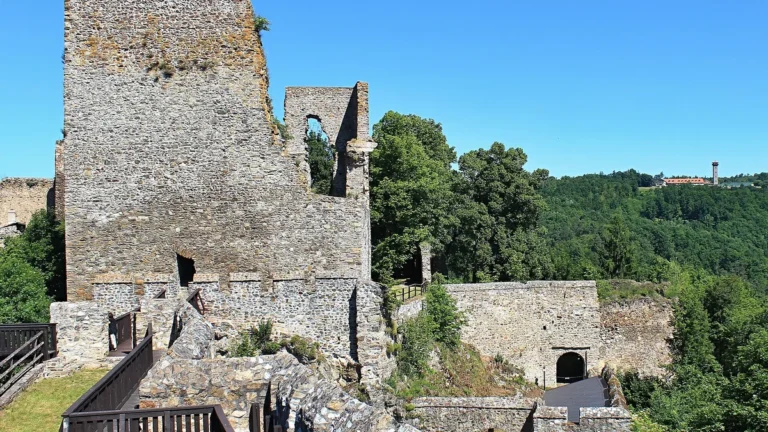 Zřícenina hradu Cornštejn s palácem, hradbami a vyhlídkovými ochozy nad lesnatým údolím Dyje