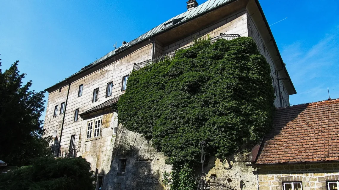 Hrad Houska, kamenný palác zarostlý zelení nad skalním podložím