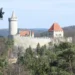 Hrad Kokořín s válcovou věží a hradbami nad lesy Kokořínského dolu