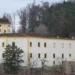 Bílý hrad Malenovice s věží na zalesněném svahu nad zlínskou částí Malenovice