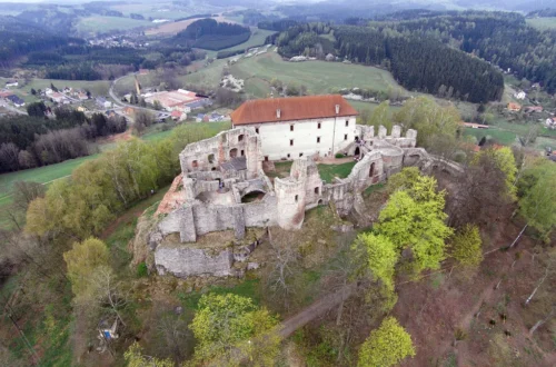 Letecký pohled na hrad Pecka s obnoveným Harantovským palácem a zříceninami nad městysem Pecka v Podkrkonoší