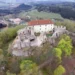 Letecký pohled na hrad Pecka s obnoveným Harantovským palácem a zříceninami nad městysem Pecka v Podkrkonoší