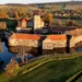 Vodní hrad Švihov z výšky v podzimních barvách, s věží, baštami a hradbami obklopenými vodním příkopem