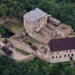 Hrad Točník z výšky s Královským a Purkrabským palácem na zalesněném hřebeni nad Žebrákem