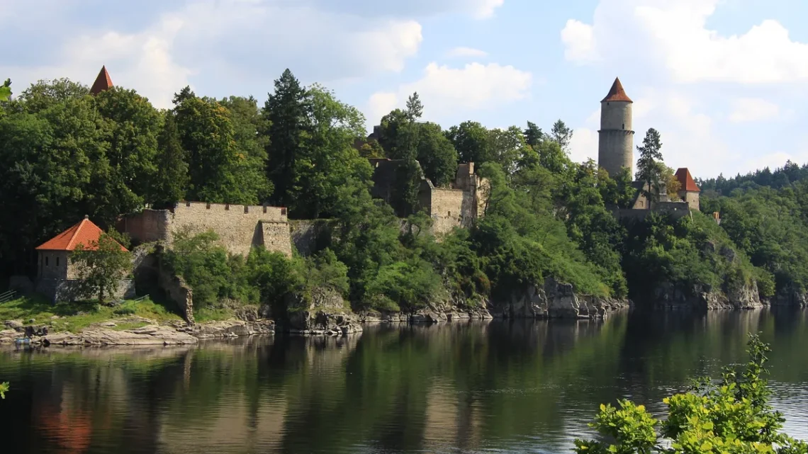 Hrad Zvíkov s Hlízovou věží a hradbami na skalním ostrohu nad hladinou Orlické nádrže, pohled od Kopaniny