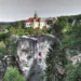 Zámek Hrubá Skála nad pískovcovými věžemi Hruboskalska, v pozadí vlevo zřícenina Trosky