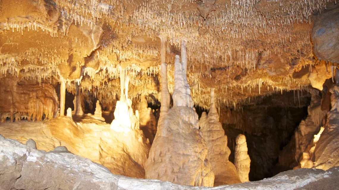 Krápníky a stalagmity pod stropem posetým brčky v Mladečských jeskyních