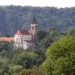 Sázavský klášter s kostelem sv. Prokopa a gotickou věží nad zalesněným údolím řeky Sázavy