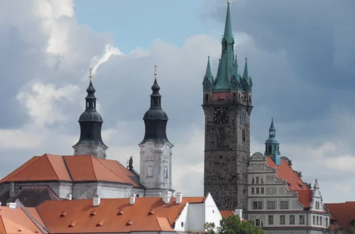Černá věž a dvě věže jezuitského kostela nad střechami Klatov