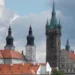Černá věž a dvě věže jezuitského kostela nad střechami Klatov
