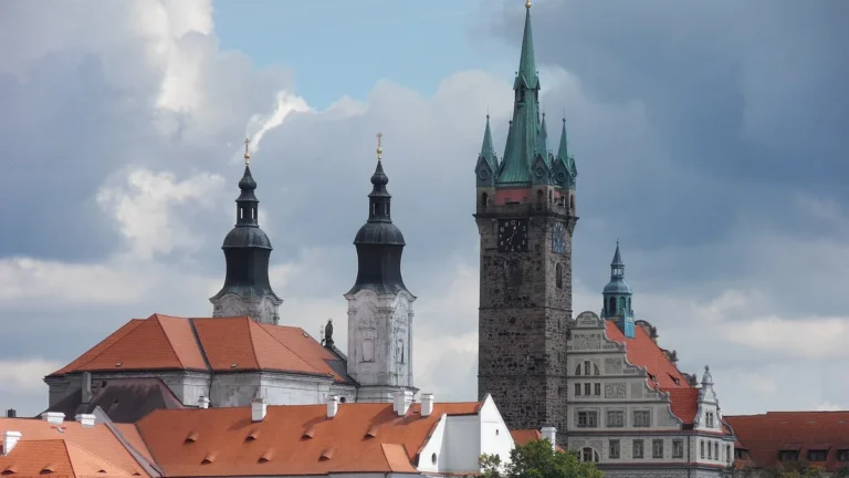 Černá věž a dvě věže jezuitského kostela nad střechami Klatov