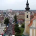 Pohled z radniční věže na kostel sv. Vavřince s hodinovou věží a na Masarykovo náměstí v Hodoníně plné stánků a lidí