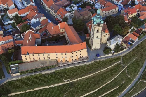Letecký pohled na zámek Mělník, chrám sv. Petra a Pavla a vinici svaté Ludmily ve svahu pod zámkem