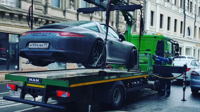 Odtahový vůz nakládá auto na městské ulici