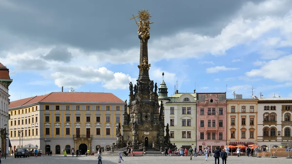 Barokní sloup Nejsvětější Trojice se zlaceným vrcholovým sousoším na Horním náměstí v Olomouci