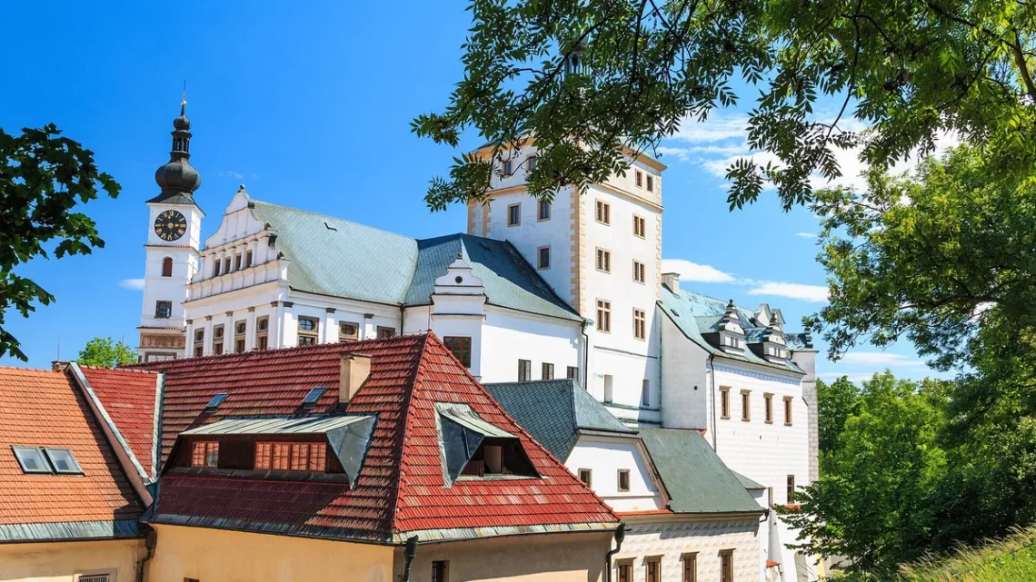Zámek Pardubice s hodinovou věží a renesančními štíty nad střechami domů v letním dni