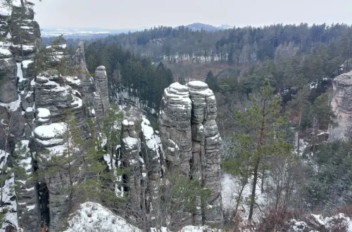 Zasněžené pískovcové věže Prachovských skal z vyhlídky Českého ráje
