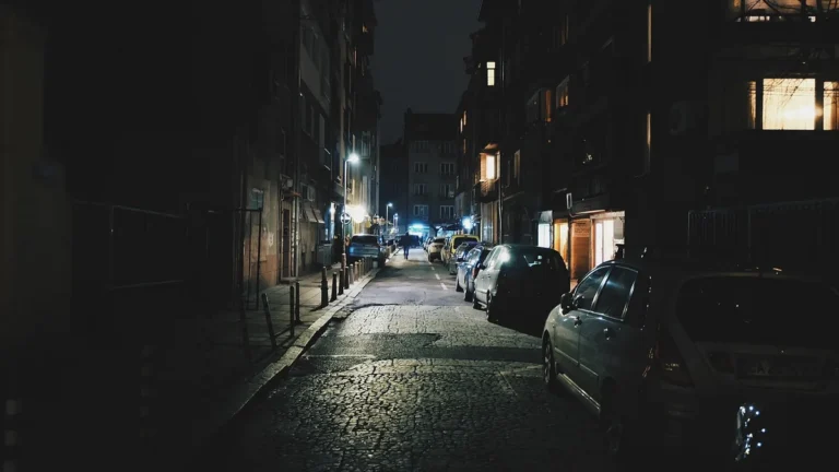 Večerní ulice se zaparkovanými auty