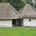 Roubené bílé domy s doškovými střechami v areálu Moravských Kopanic ve skanzenu Strážnice