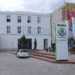 Bílá budova Škoda Muzea na třídě Václava Klementa v Mladé Boleslavi se sochou zakladatelů a stojanem s logem Škoda