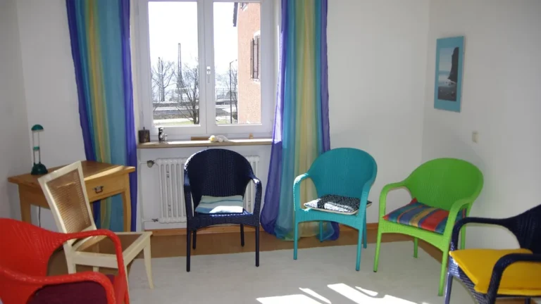 Světlá poradna s barevnými židlemi