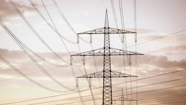 Sloup vysokého napětí a dráty před oblohou