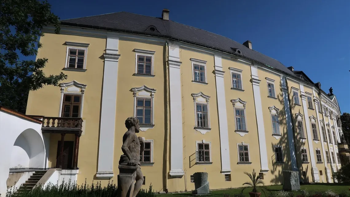 Barokní průčelí zámku Bruntál se sochou Vulkána v zámecké zahradě