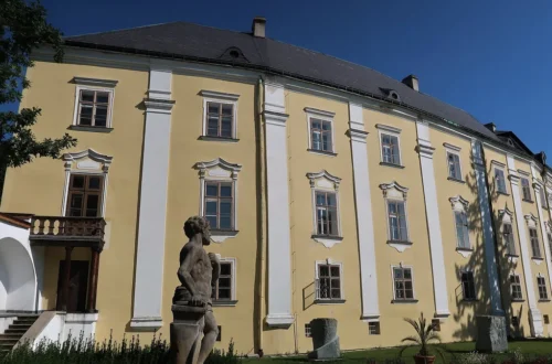 Barokní průčelí zámku Bruntál se sochou Vulkána v zámecké zahradě