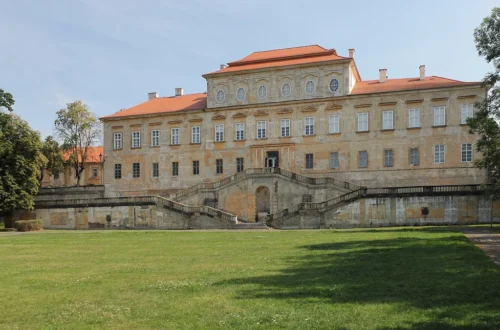Barokní zámek Duchcov s dvouramenným schodištěm při pohledu ze zámeckého parku