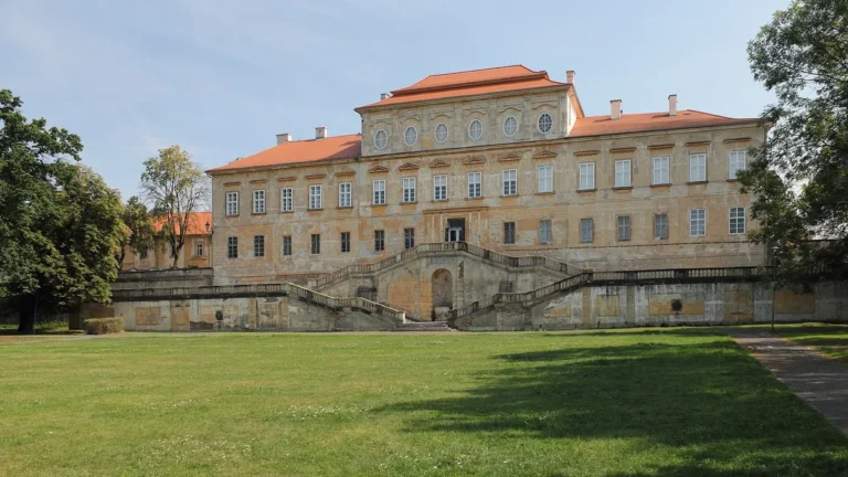 Barokní zámek Duchcov s dvouramenným schodištěm při pohledu ze zámeckého parku