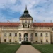 Zahradní průčelí nového zámku v Hořovicích s věží s hodinami a trávníkem před vchodem