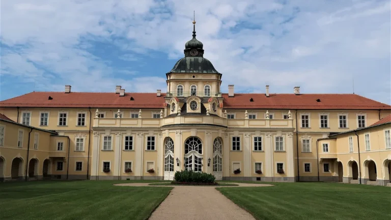 Zahradní průčelí nového zámku v Hořovicích s věží s hodinami a trávníkem před vchodem