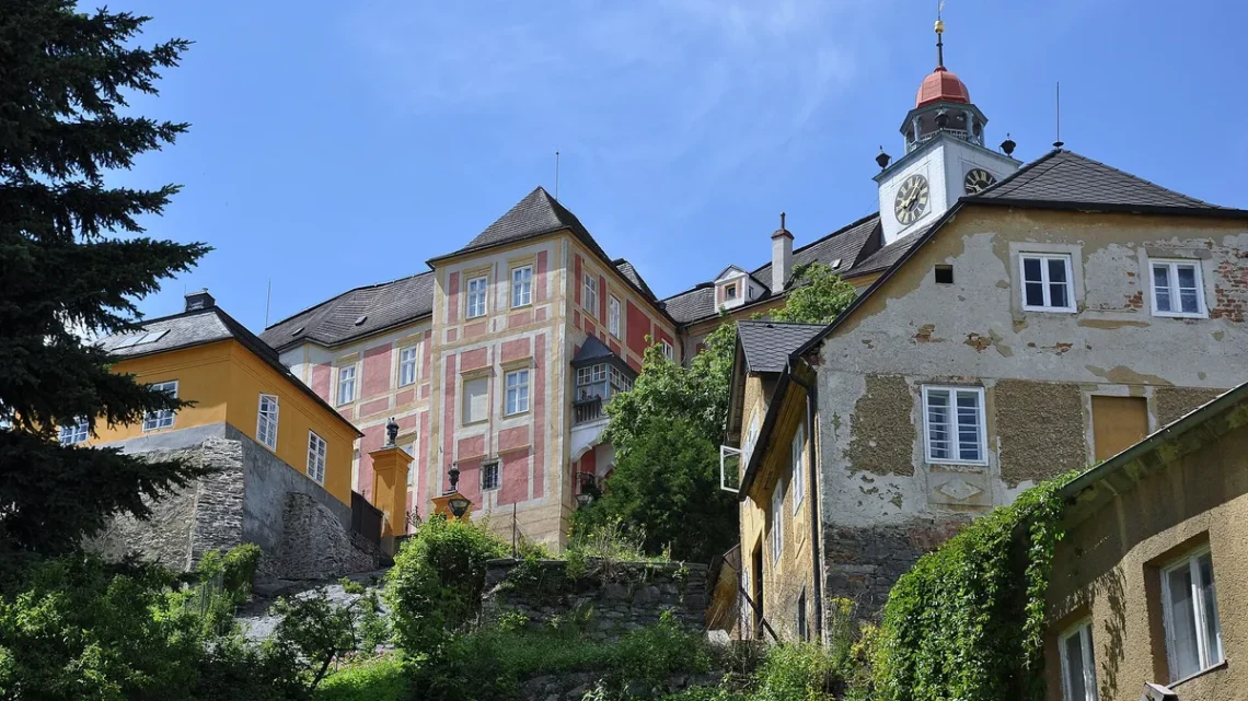 Zámek Jánský Vrch s hodinovou věží na skalnatém kopci nad Javorníkem