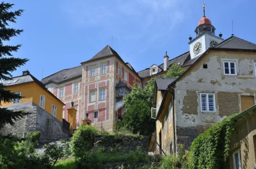 Zámek Jánský Vrch s hodinovou věží na skalnatém kopci nad Javorníkem
