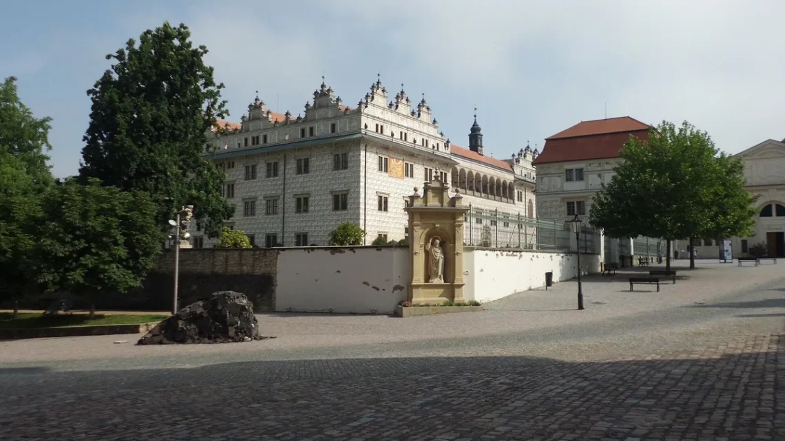 Renesanční zámek Litomyšl se sgrafitovou fasádou a arkádami za ohradní zdí s barokní sochou