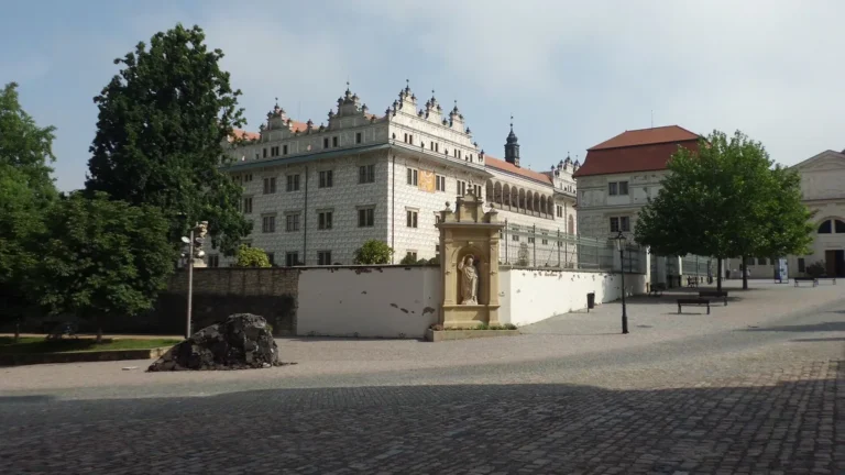 Renesanční zámek Litomyšl se sgrafitovou fasádou a arkádami za ohradní zdí s barokní sochou