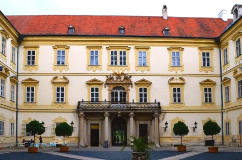 Vnitřní nádvoří zámku Valtice s balkonem nad vstupem a stromky v kbelících