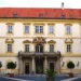Vnitřní nádvoří zámku Valtice s balkonem nad vstupem a stromky v kbelících