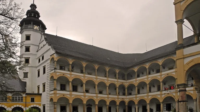 Arkádové nádvoří renesančního zámku Velké Losiny s osmibokou věží s hodinami a ochozy se žlutými oblouky